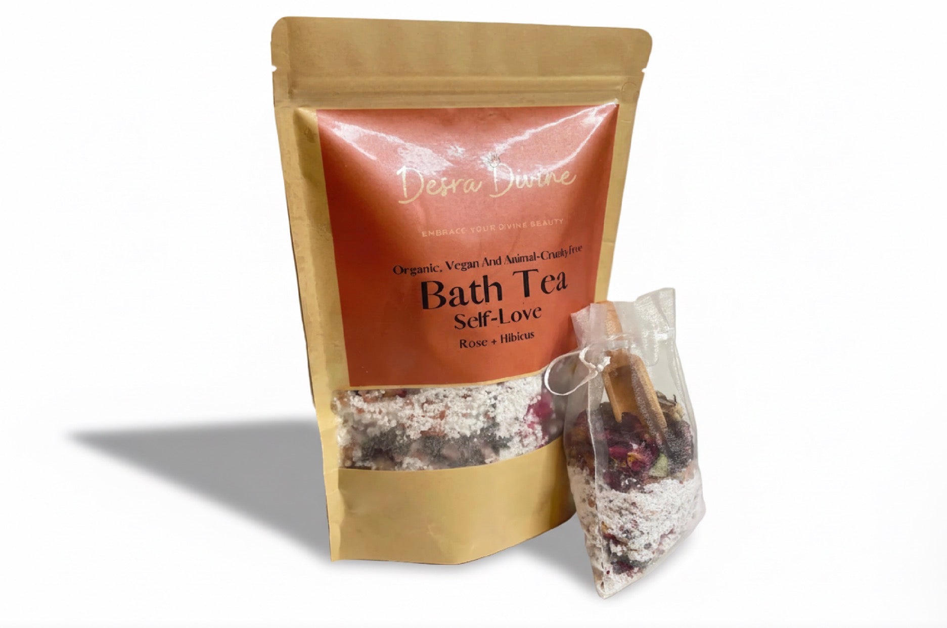 Bath tea package with a smaller white bag of bath tea and a wooden spoon on a white background
